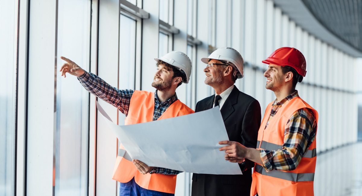 Architect man showing something on project to his colleague foreman.